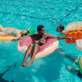 Grupo de personas en una piscina con hinchables fantasía. (Pexels)