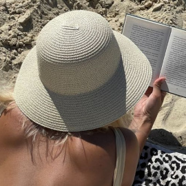 Chica leyendo un libro en la playa. (Fuente: Unsplash)