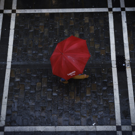 Un viandante se protege de la lluvia en Pamplona (Navarra), en una imagen de archivo.