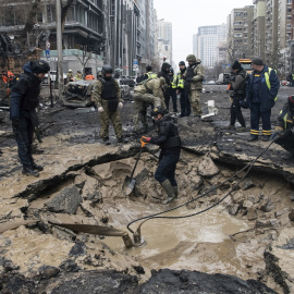 Trabajadores drenan el agua de un agujero tras un bombardeo en el centro de Kiev, Ucrania, a 20 de diciembre de 2024.