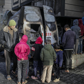 Palestinos inspeccionan un vehículo destruido cerca del hospital Al Awda tras un ataque aéreo israelí en el campamento de refugiados de Al Nuseirat, en el centro de la Franja de Gaza, el 26 de diciembre de 2024.