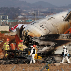 Bomberos trabajan entre los restos del avión de Jeju Air en el aeropuerto de Muan, Corea del Sur.