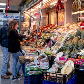 Varias personas hacen compras de última hora en un mercado, a 31 de diciembre de 2024, en Madrid (España).