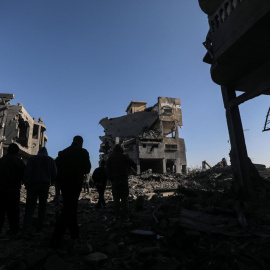 Palestinos inspeccionan las ruinas de una vivienda destruida por los ataques israelíes sobre la Franja de Gaza.