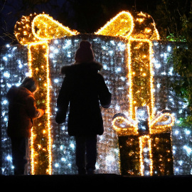 Niños delante de una iluminación de un paquete de regalo, a 11 de diciembre de 2024.