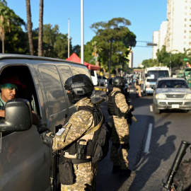 Un militar venezolano revisa los documentos de un conductor en un puesto de control, en Caracas, a 8 de enero de 2025.