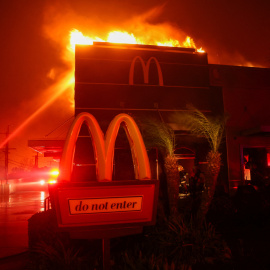 Los bomberos trabajan para extinguir las llamas mientras el incendio arde en Pasadena, California, EEUU.