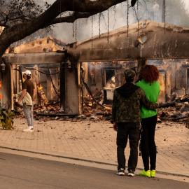 Personas observan una casa afectada por un incendio este miércoles, en Altadena, California, a 8 de enero de 2024.