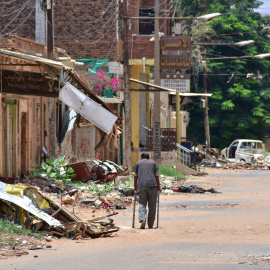 Un hombre camina por una calle marcada por la destrucción, mientras una sangrienta lucha por el poder asola Sudán desde hace más de dos años.