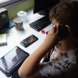 Imagen de archivo de un niño utilizando dispositivos digitales.