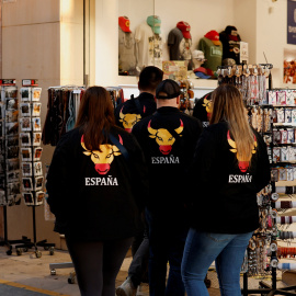 Un grupo de turistas, con sudaderas con una imagen de un toro con los colores de la bandera española, en una tienda de souvenirs, en la localidad malagueña de Rondas.