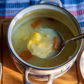 Imagen de un plato de crema de patatas, zanahorias y pollo.