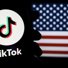 Un teléfono con el logo de TikTok junto a la bandera de EEUU.