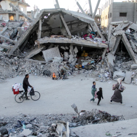 Una familia palestina camina junto a los edificios destruidos por los bombardeos israelíes, en el campo de refugiados de Jabalia, en el norte de la Franja de Gaza.