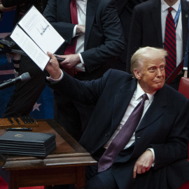 El presidente de los Estados Unidos, Donald Trump, muestra una orden ejecutiva que firmó en un desfile de inauguración presidencial.