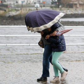 Imagen de archivo de dos personas caminando con dificultad por el viento en Viveiro, a 8 de enero de 2025, en Lugo.