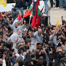 Cientos de personas y familiares reciben al centenar de presos palestinos que han sido liberados por Israel en Cisjordania, este sábado en un centro de Ramala dispuesto para su recibimiento.