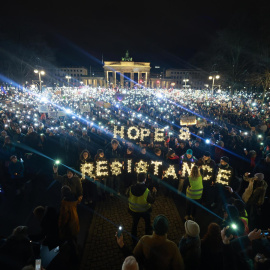 Participantes sostienen luces durante una concentración contra la extrema derecha en la Puerta de Brandemburgo en Berlín, Alemania, 25 de enero de 2025.