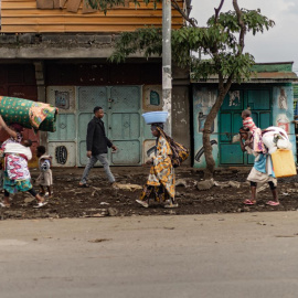 Civiles huyen con sus enseres de la violencia en Mugini, ciudad muy cercana a Goma, en República Democrática del Congo.