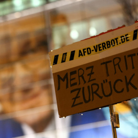 Un manifestante sostiene un cartel que dice "¡Merz dimite!" durante una protesta frente a la sede de la CDU en Berlín, tras la aprobación en el Bulndestag de una moción contra la inmigración.