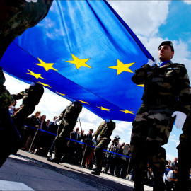 Soldados sostienen la bandera de la Unión Europea.