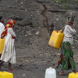 Varias mujeres portan bidones en un campo de desplazados, en Goma (República Democrática del Congo), a 3 de febrero de 2025.