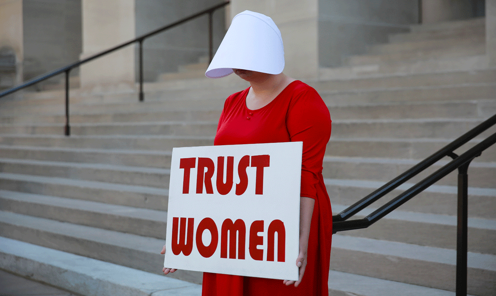 07/05/2019 - Una mujer vestida como sierva sostiene un letrero que dice "Confía en las mujeres" en protesta por el proyecto de ley contra el aborto de Georgia | REUTERS / Elijah Nouvelage