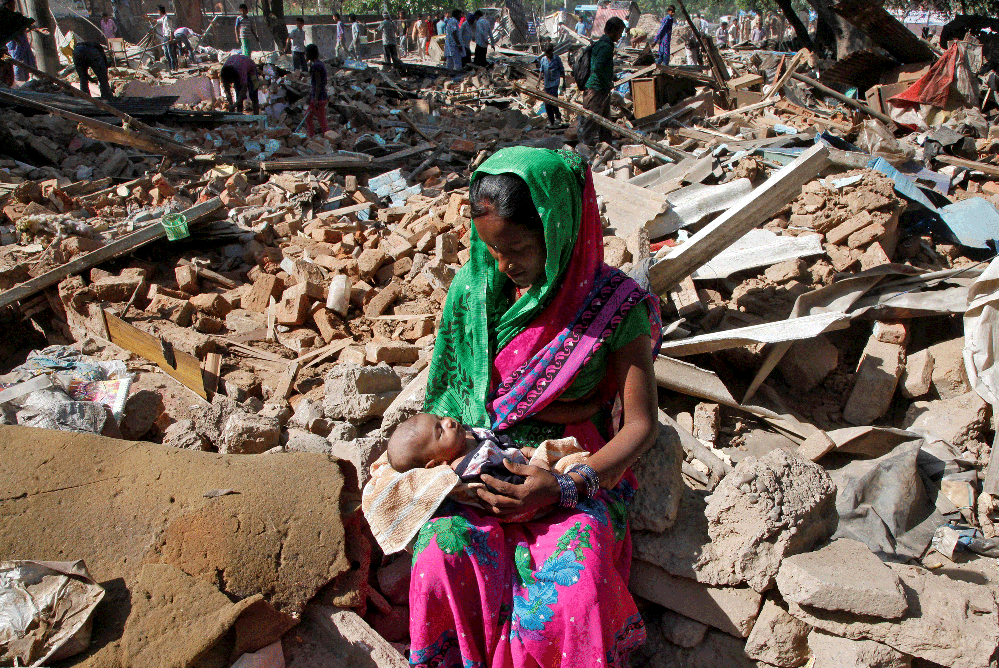 Una mujer amamanta a su hijo después de que su casa fuera destruída por las autoridades locales de Chandigarh, India. REUTERS/Ajay Verma