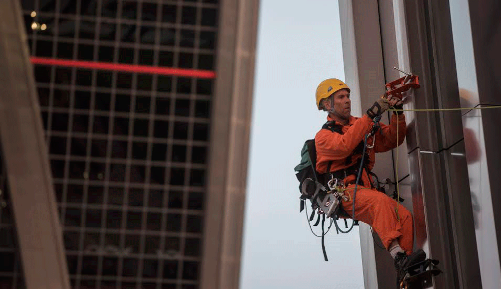 Un activista de Greenpeace colgado de una de las torres Kio en una acción contra el TTIP este martes en Madrid. GREENPEACE