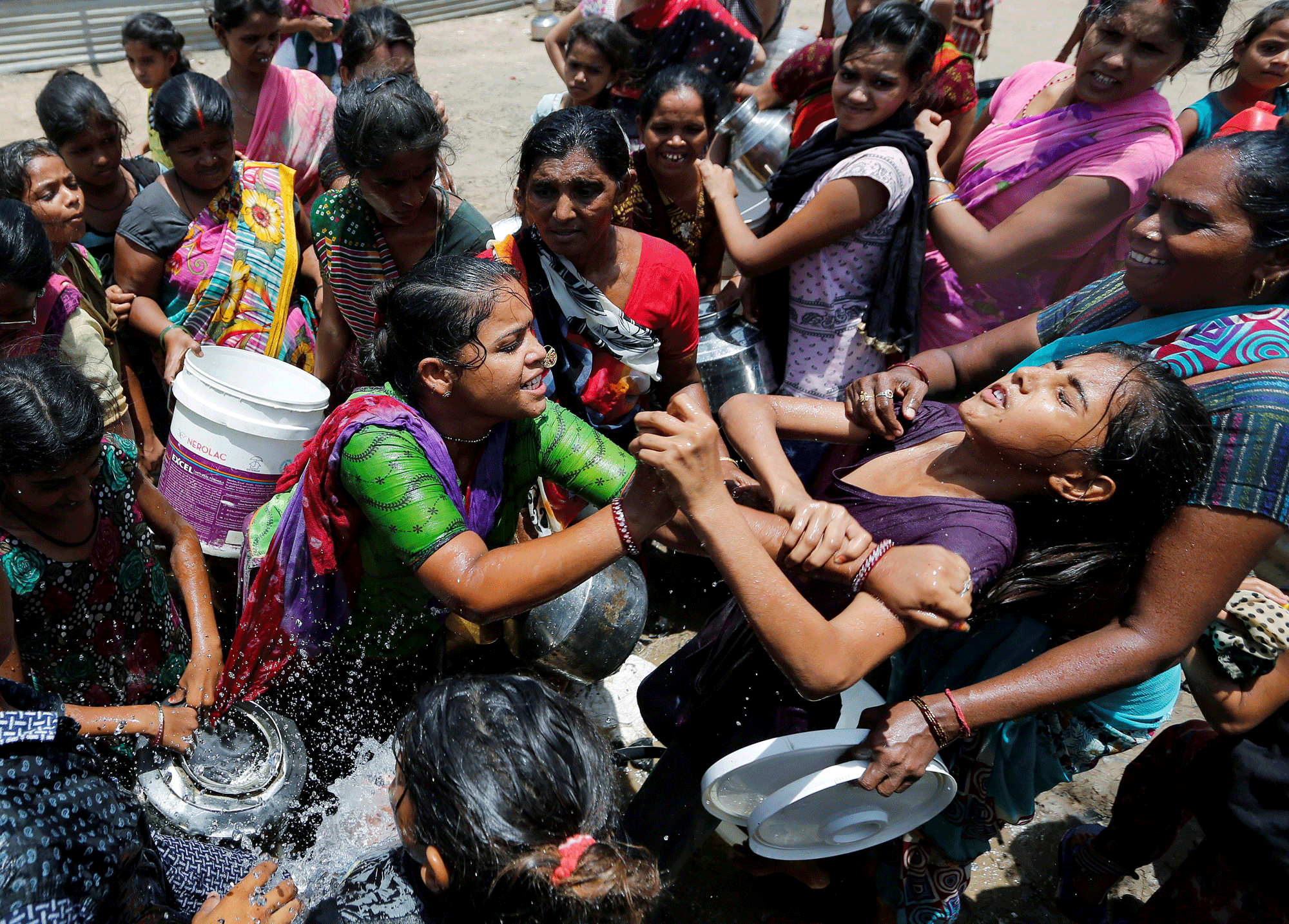 Un grupo de indias 'se pelean' para beber agua de un camión cisterna, que el gobierno de la ciudad de Ahmedabad suministra para sobrellevar el caluroso verano indio. REUTERS/Amit Dave