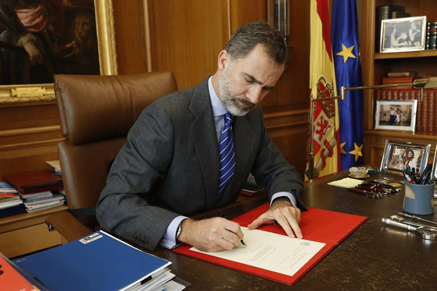 El rey Felipe VI firma, en su despacho del Palacio de la Zarzuela, el Real Decreto con el nombramiento de Mariano Rajoy.- EFE